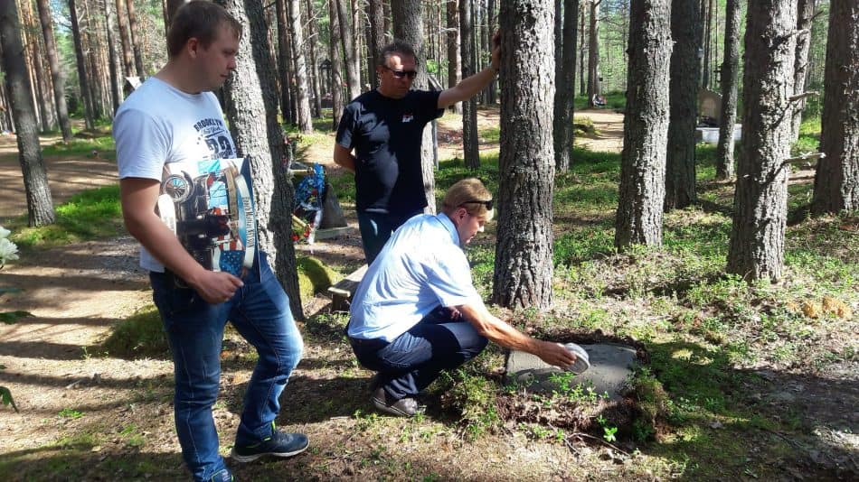 Сергей Нельсон высыпает родную землю в могилу